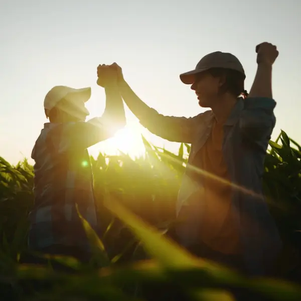 foto-interior-equipo Dos miembros de un equipo chocándose las manos en un campo